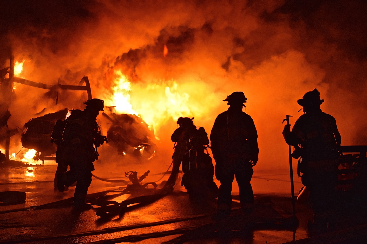 a group of firefighters standing near a fire